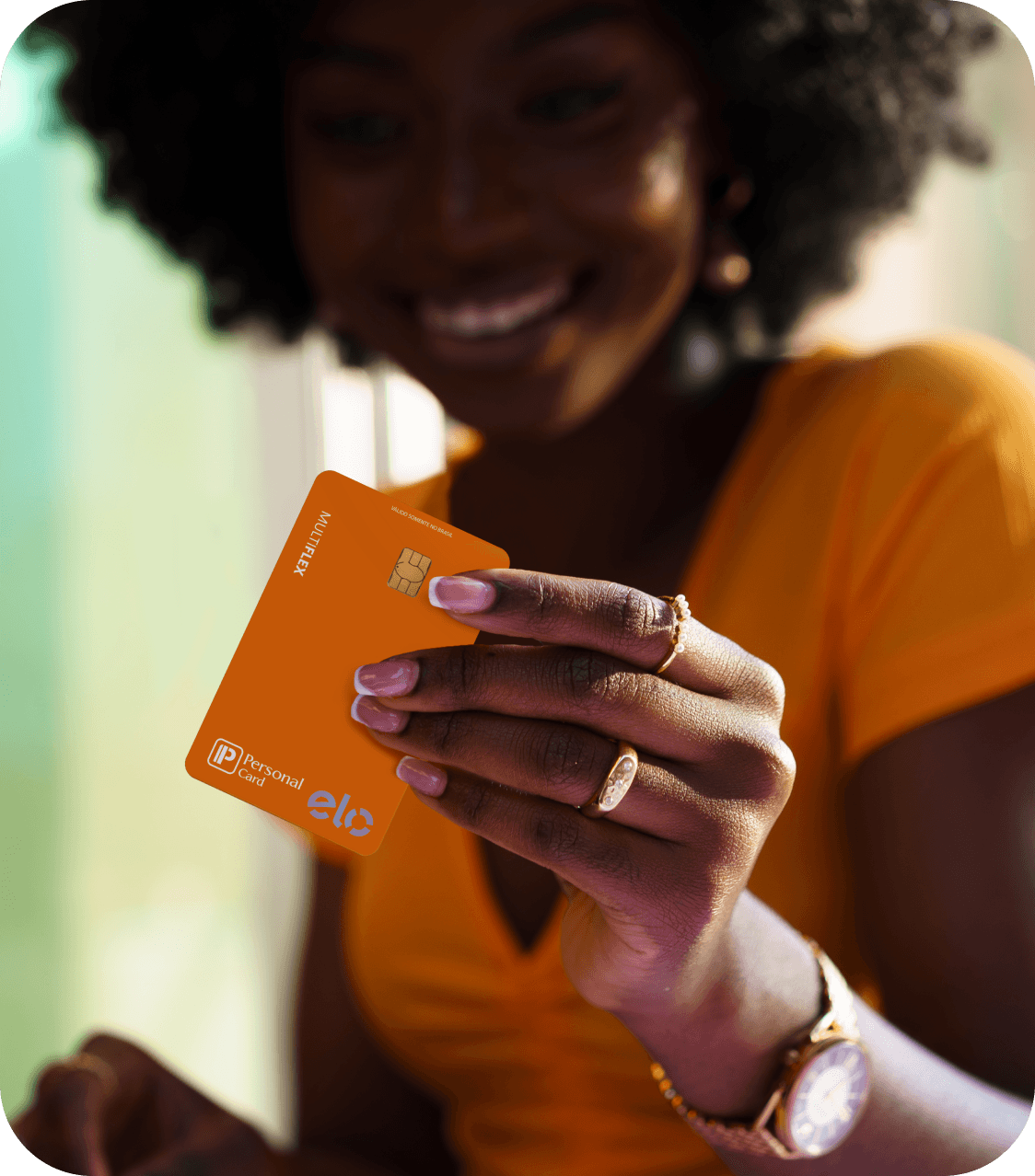 Mulher sorrindo segurando um cartão de benefícios, representando cliente Personal Card